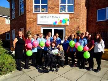 Home Manager Karen Neal (centre; crouched down) with Exemplar service user and her team.